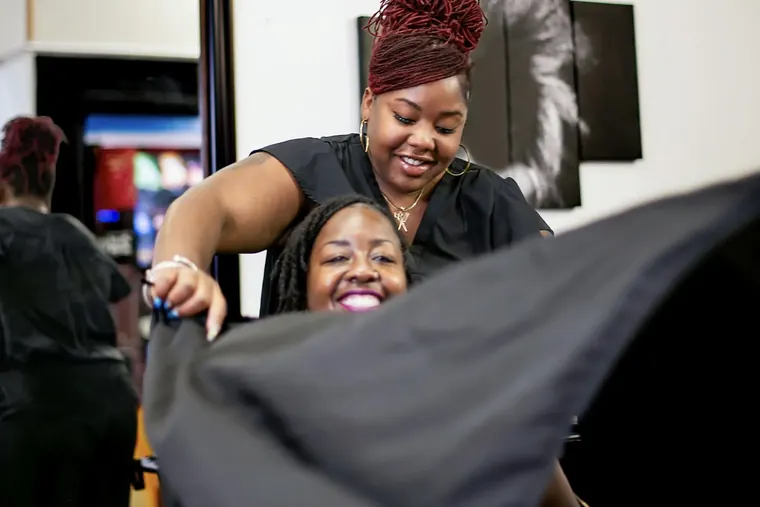A stylist and a laughing client at the chair